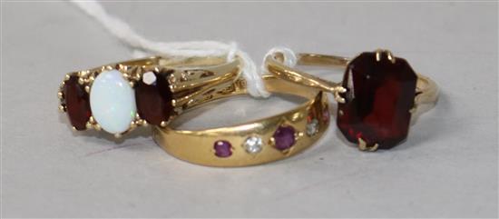 A 9ct gold, opal and garnet ring, scrolled carved mount, an 18ct gold, ruby and diamond gypsy-set ring and another 9ct gold ring